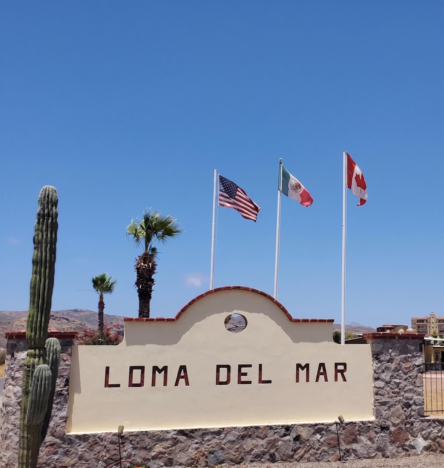 Loma del Mar entrance sign with American, Mexican, and Canadian flags